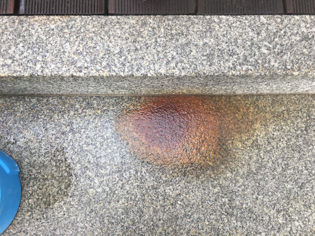 Starker Rostfleck auf Granittreppenstufe vor der Reinigung
